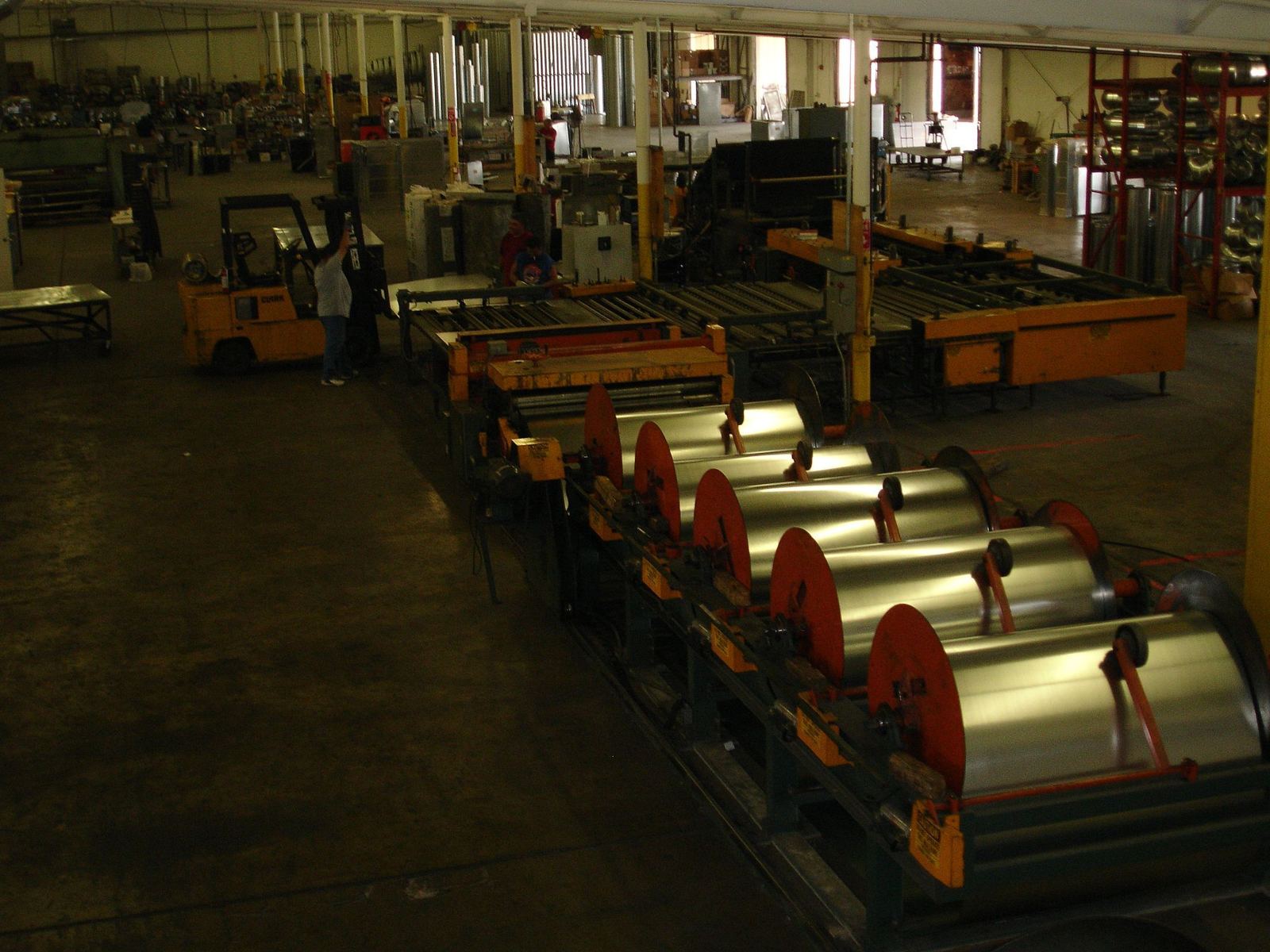 Coils of sheet metal staged on the shop floor